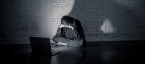Distressed young girl sitting in front of laptop